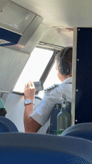 Pilot checks smartphone in aircraft cockpit near Batumi
