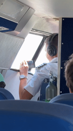 Pilot checks smartphone in aircraft cockpit near Batumi
