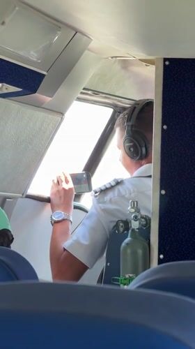 Pilot checks smartphone in aircraft cockpit near Batumi