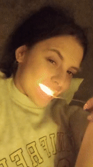 Person poses with light source while lying down, smiling