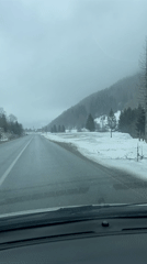 Vehicle drives through snowy Montenegro mountains in winter conditions