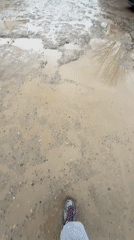Pedestrian navigates flooded muddy streets in Sofia Bulgaria
