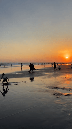 Bali beach day: kites, crowds, and a wedding arch at sunset