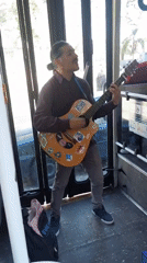 Street musician performs with guitar on Buenos Aires bus