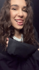 Young woman dances playfully for camera in Vysokaya Gora