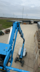Rental boom lifts operate in commercial yard, Lelystad