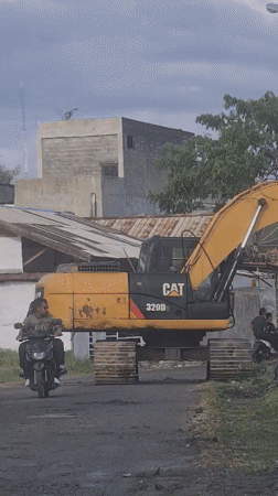 Excavator conducts roadwork in Lhokseumawe residential area