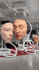 Realistic human face sculptures displayed in Paris indoor venue