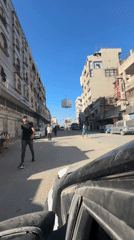 Inside a car on a cobblestone Gaza street, selfie in progress