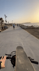 Cyclist tours Tel Aviv waterfront during Mediterranean sunset