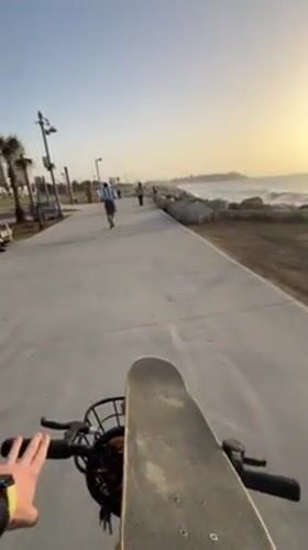 Cyclist tours Tel Aviv waterfront during Mediterranean sunset
