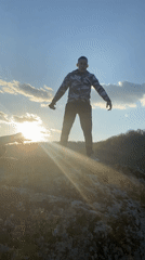 Two young men filmed on rocky outcrop at sunset, Goritsa