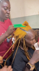 Box braids going in at a Jos hair salon
