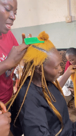 Box braids going in at a Jos hair salon