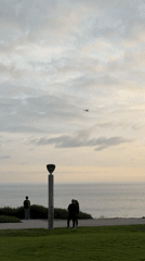 Lamppost observed near ocean under cloudy Dana Point sky