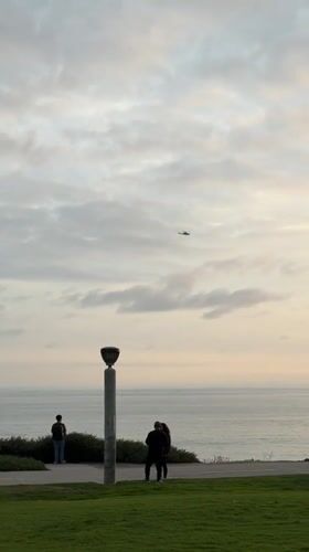 Lamppost observed near ocean under cloudy Dana Point sky