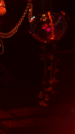 Disco ball reflects colored lights in dark Moscow room