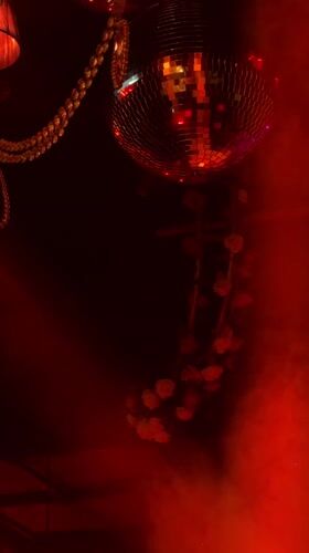 Disco ball reflects colored lights in dark Moscow room