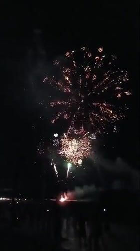 Nighttime fireworks display draws a crowd at a waterfront venue