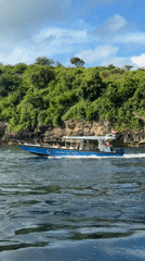 Tourist boat spotted cruising near rocky island in Nusa Penida