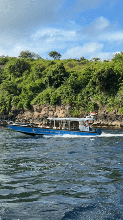 Tourist boat spotted cruising near rocky island in Nusa Penida