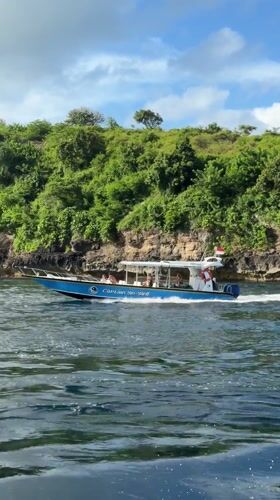 Tourist boat spotted cruising near rocky island in Nusa Penida