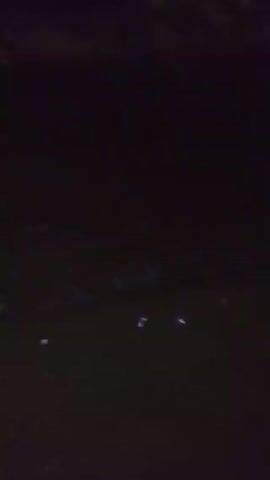 The video begins in darkness, but as the camera adjusts, it reveals a street lit by a streetlamp. The street surface is covered in what appears to be snow or hail. There are no people visible in the frame. The video ends abruptly.