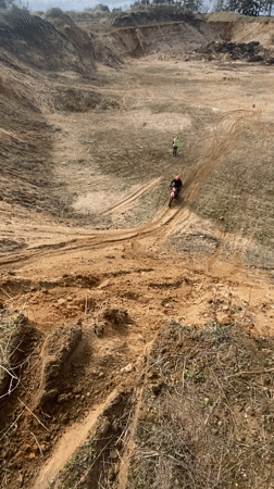 Dirt biker struggles through muddy quarry terrain in Belarus