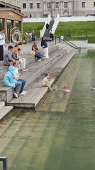 Toy boats and a rubber duck drift on a Kazan pond