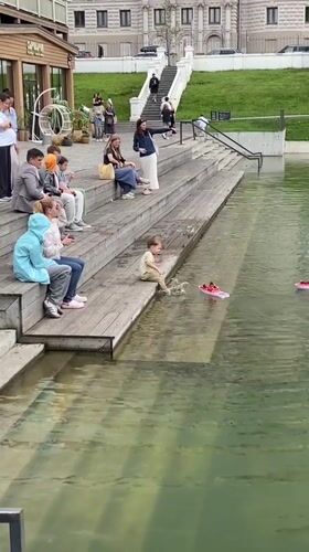 Toy boats and a rubber duck drift on a Kazan pond