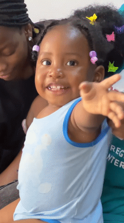 Toddler plays at home while water collected in Jos