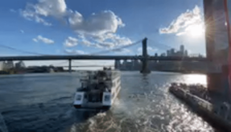 Evening boat activity around Manhattan Bridge from East River