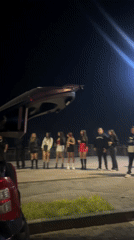 Young adults gather around car sound system in Arica