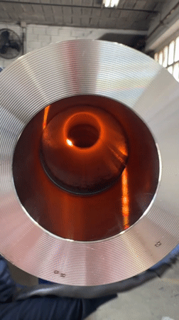 Worker handles glowing hot metal pipe in Barcelona