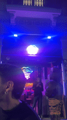 Evening social gathering documented at Barcelona venue with neon lighting