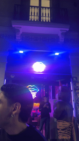 Evening social gathering documented at Barcelona venue with neon lighting