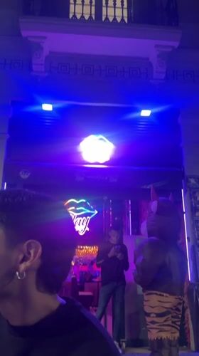 Evening social gathering documented at Barcelona venue with neon lighting