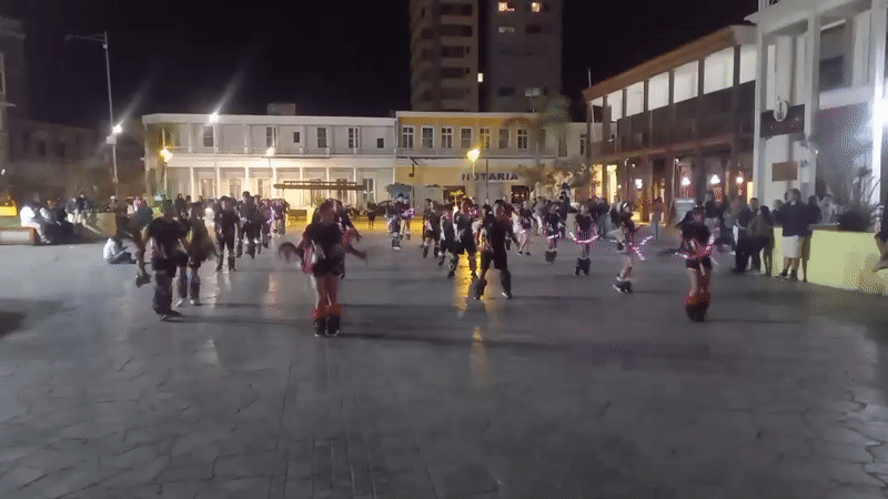 Costumed dancers perform nighttime plaza show in Iquique