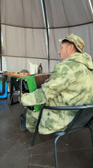 Camouflaged musician plays accordion in Russian gazebo