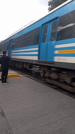 Train crosses road near pedestrians in Buenos Aires