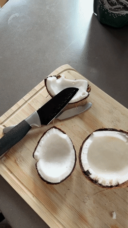 Fresh coconut cracked open on a cutting board in Fife