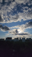 Urban skyline captured under cloudy skies with sunlight