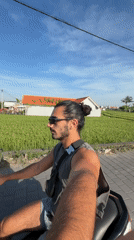 Motorcyclist films selfie video on rural road in North Kuta