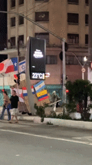 Night street scene in São Paulo with flags and digital display
