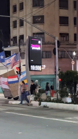 Night street scene in São Paulo with flags and digital display