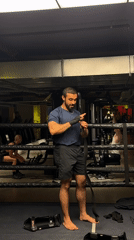 Boxer prepares equipment for training session in London gym