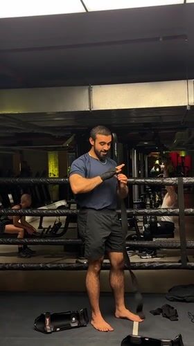 Boxer prepares equipment for training session in London gym