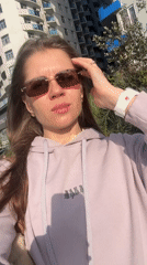 Woman poses for selfies on Batumi street amid urban scenery