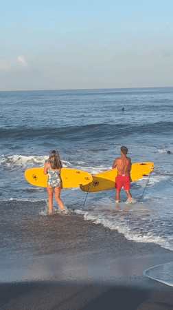 Beach day with surfboards and paddleboarding in North Kuta