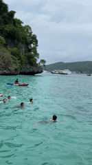 Morning swimmers and kayakers enjoy Haad Hin Khom waters